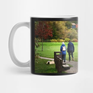 Old couple walking on a path in the park Mug